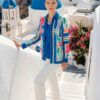 Chaqueta ligera de corte recto con un vibrante estampado de paneles florales en tonos azules y fucsias. Presenta cierre de cremallera frontal y cuello camisero, perfecta para completar conjuntos de primavera con un toque de color exclusivo.